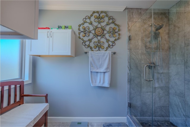 bathroom featuring crown molding, baseboards, and a shower stall