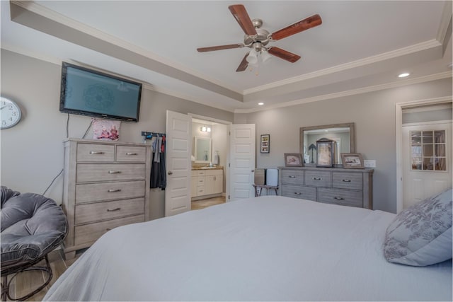 bedroom featuring a tray ceiling, crown molding, recessed lighting, ensuite bath, and a ceiling fan