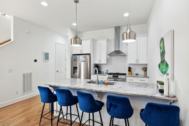 1930D Herman St, Nashville, TN 37208 - kitchen with visible vents, white cabinetry, wall chimney range hood, and appliances with stainless steel finishes