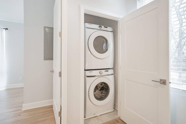 1930D Herman St, Nashville, TN 37208 - laundry area featuring stacked washer / dryer, electric panel, baseboards, laundry area, and light wood-type flooring