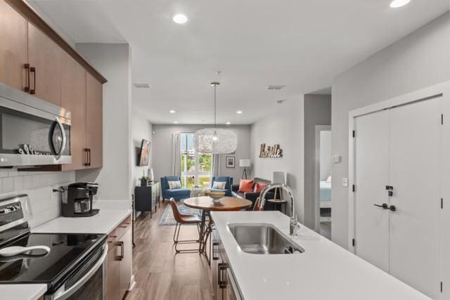 5403 Centennial Blvd Unit 203, Nashville, TN 37209 - kitchen featuring light countertops, a sink, appliances with stainless steel finishes, and light wood-style floors