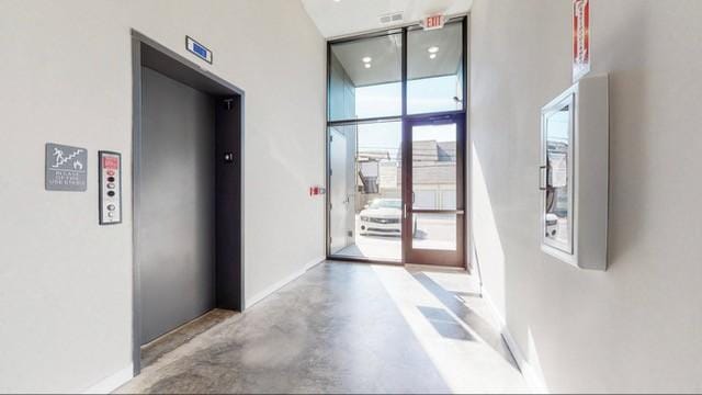 5403 Centennial Blvd Unit 203, Nashville, TN 37209 - hallway with expansive windows, elevator, baseboards, and concrete flooring