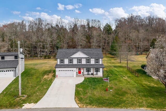 view of front of home featuring an attached garage, concrete driveway, a front yard, a shingled roof, and a porch