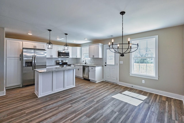 kitchen with dark wood-type flooring, a notable chandelier, white cabinetry, and stainless steel appliances