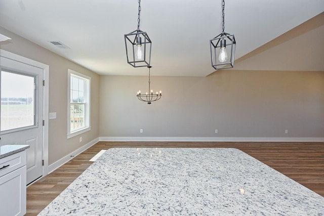dining area featuring a chandelier, baseboards, light wood finished floors, and visible vents