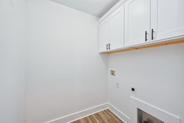 clothes washing area with light wood finished floors, washer hookup, electric dryer hookup, baseboards, and cabinet space