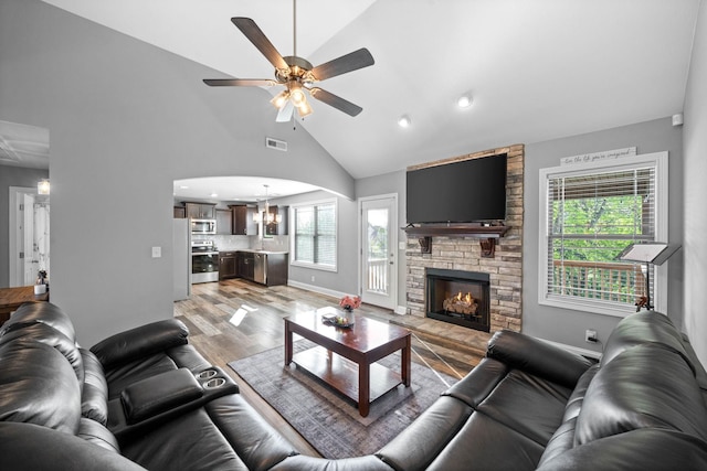 2263 Allen Griffey Ct, Clarksville, TN 37042 - living area with a stone fireplace, visible vents, ceiling fan with notable chandelier, high vaulted ceiling, and light wood-type flooring
