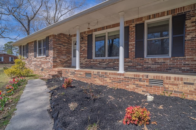 exterior space with covered porch and brick siding