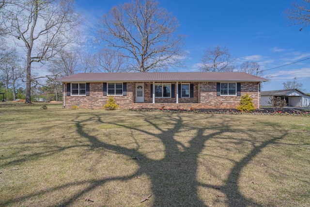 view of front of home with metal roof, a front yard, and brick siding