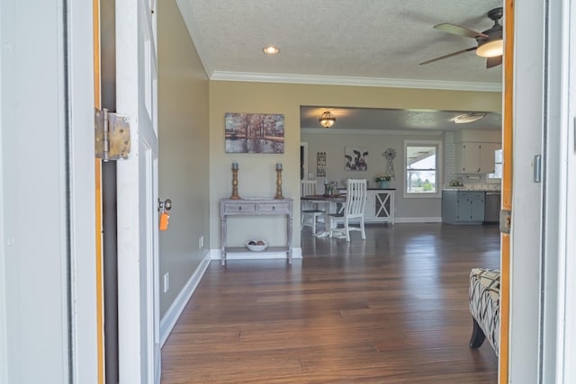 entrance foyer featuring dark wood-type flooring, a textured ceiling, baseboards, ceiling fan, and ornamental molding