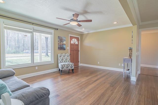 sitting room with a textured ceiling, ceiling fan, wood finished floors, and ornamental molding