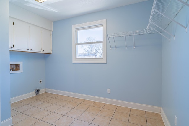 clothes washing area featuring light tile patterned floors, baseboards, cabinet space, electric dryer hookup, and washer hookup