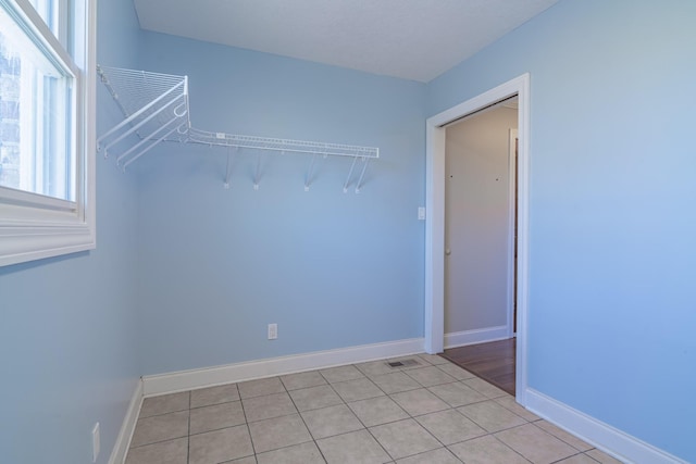 spare room with light tile patterned floors and baseboards