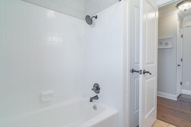 bathroom featuring  shower combination, ornamental molding, and baseboards