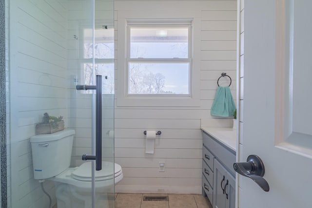bathroom featuring toilet, vanity, tile patterned flooring, a shower with shower door, and visible vents