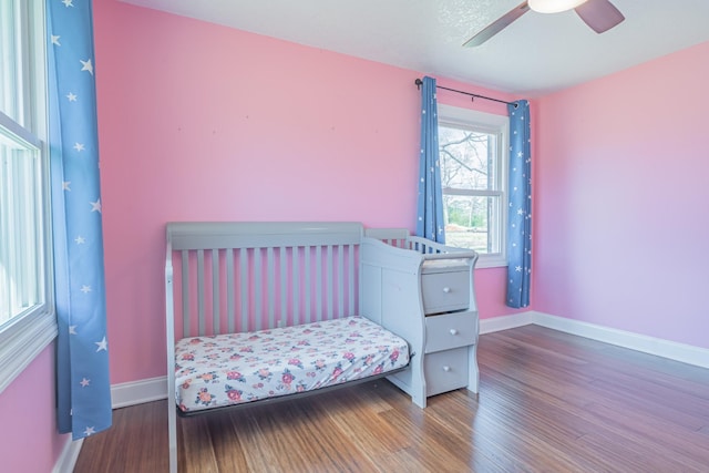 bedroom with baseboards, ceiling fan, and wood finished floors