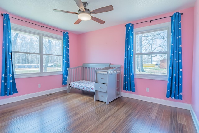 unfurnished bedroom with baseboards, visible vents, wood finished floors, and a textured ceiling