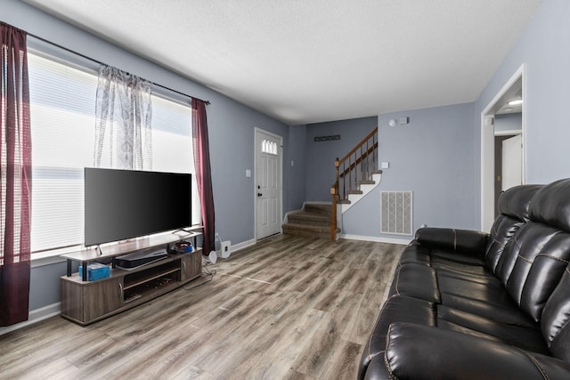 1571 Barrett Dr, Clarksville, TN 37043 - living area featuring stairs, baseboards, a textured ceiling, visible vents, and wood finished floors