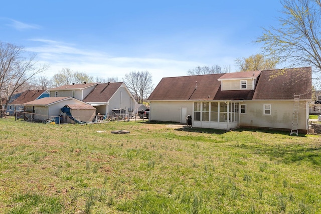 1571 Barrett Dr, Clarksville, TN 37043 - rear view of property with a lawn, a sunroom, fence, and a fire pit