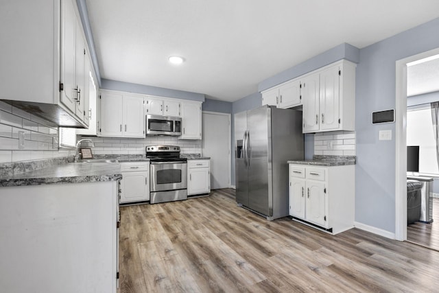 1571 Barrett Dr, Clarksville, TN 37043 - kitchen featuring white cabinets, a sink, stainless steel appliances, and light wood-style flooring