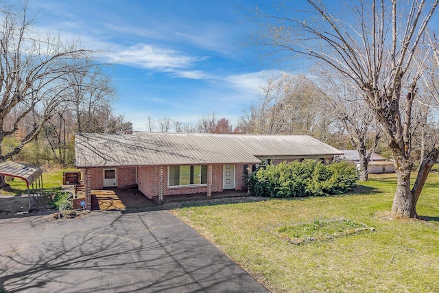 view of front facade with brick siding, a front yard, and aphalt driveway