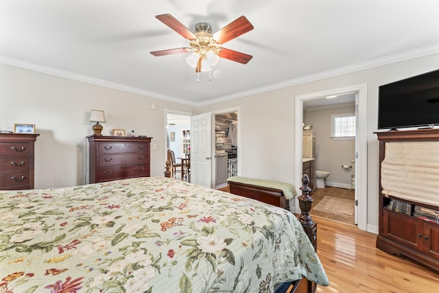 bedroom with a ceiling fan, a walk in closet, light wood-style flooring, ensuite bath, and ornamental molding