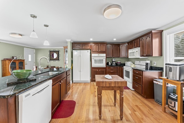 kitchen with white appliances, crown molding, light wood-style flooring, and a sink