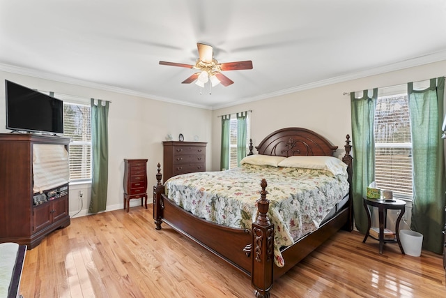 bedroom with crown molding, baseboards, light wood finished floors, and ceiling fan