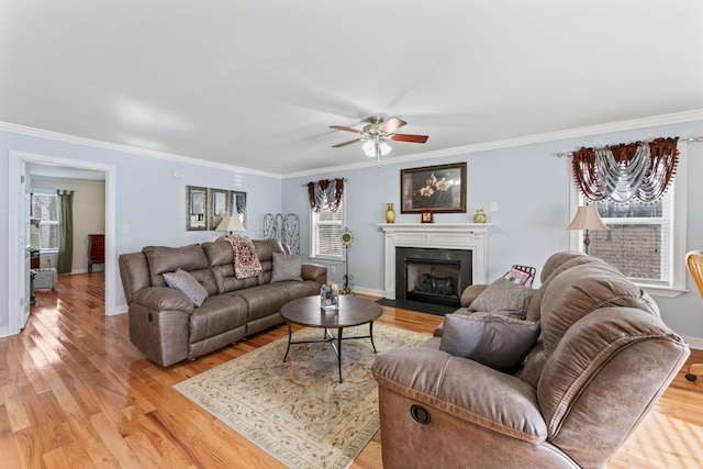 living area featuring a wealth of natural light, light wood-style floors, and a ceiling fan
