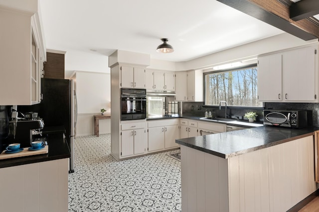 409 Cunniff Pkwy, Goodlettsville, TN 37072 - kitchen featuring tasteful backsplash, oven, a sink, dark countertops, and a peninsula