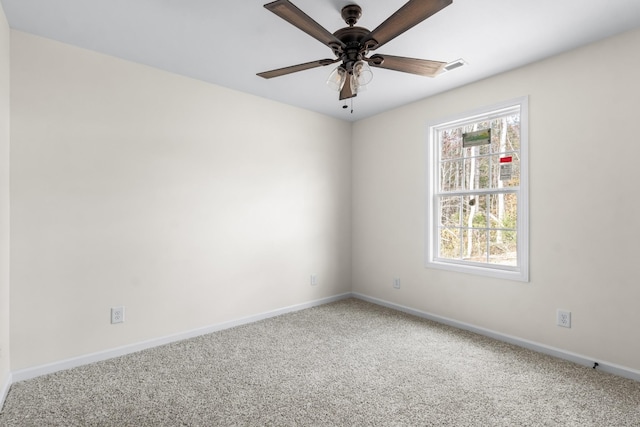 empty room with baseboards, carpet floors, ceiling fan, and visible vents