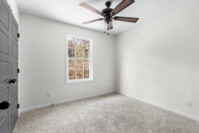 carpeted empty room featuring baseboards and ceiling fan