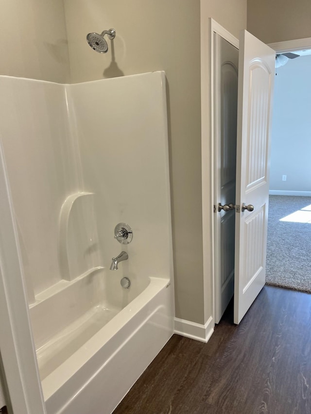 full bath with baseboards, shower / tub combination, and wood finished floors