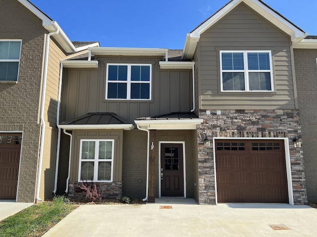 multi unit property featuring stone siding, board and batten siding, concrete driveway, and a garage