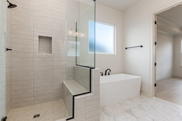 bathroom featuring crown molding, a freestanding tub, tiled shower, and baseboards