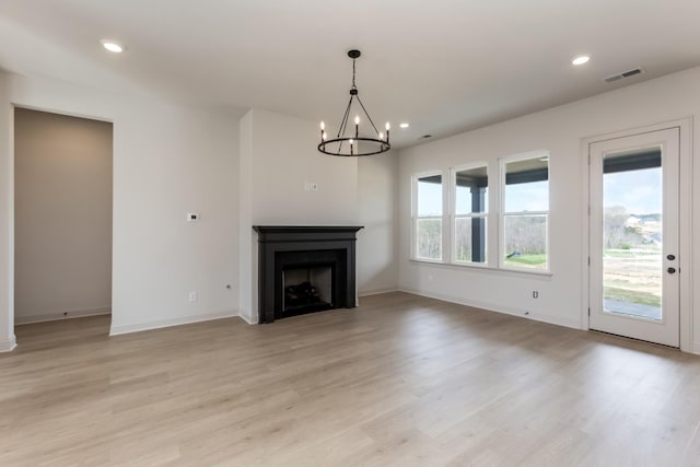 unfurnished living room featuring light wood-style floors, recessed lighting, visible vents, and an inviting chandelier