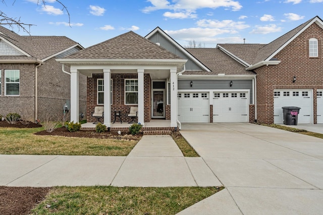 view of front of home with covered porch, brick siding, driveway, and roof with shingles