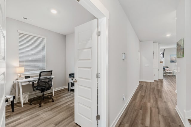 corridor with light wood finished floors, baseboards, visible vents, and recessed lighting