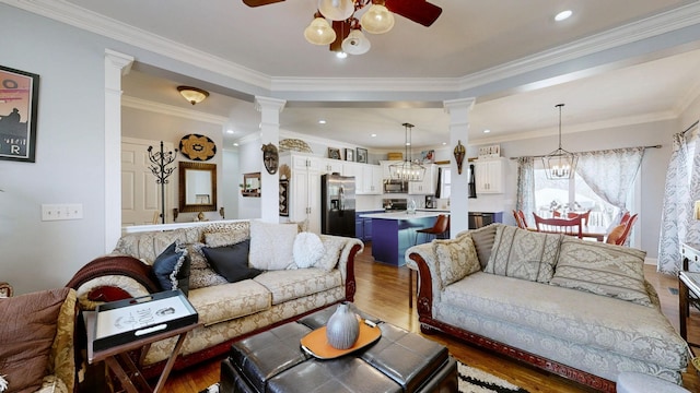 510 Castleview Dr, Lebanon, TN 37087 - living area featuring ornate columns, crown molding, wood finished floors, and ceiling fan with notable chandelier