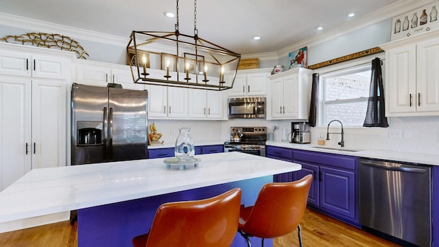 510 Castleview Dr, Lebanon, TN 37087 - kitchen with a kitchen breakfast bar, crown molding, stainless steel appliances, blue cabinets, and a sink