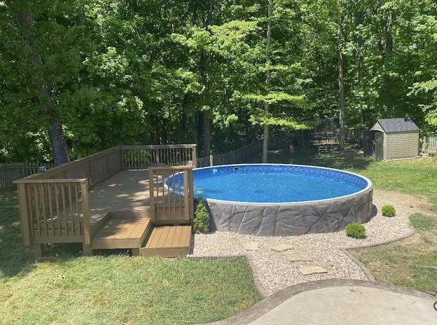 4425 Taylor Hall Ln, Adams, TN 37010 - pool featuring a storage unit, an outbuilding, a deck, and fence private yard