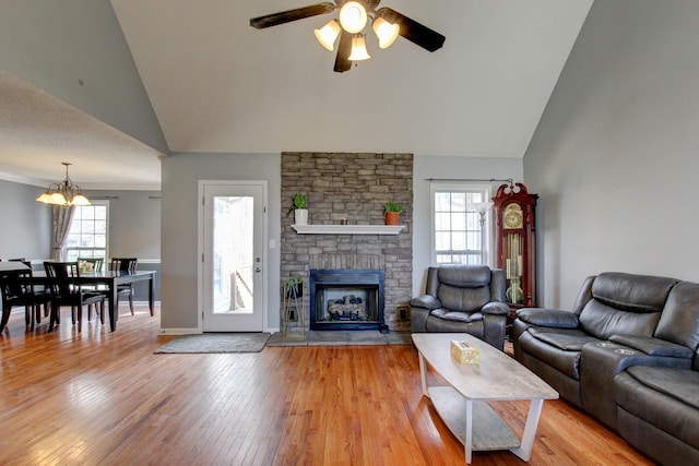 4425 Taylor Hall Ln, Adams, TN 37010 - living area with a stone fireplace, ceiling fan with notable chandelier, high vaulted ceiling, and light wood-style flooring