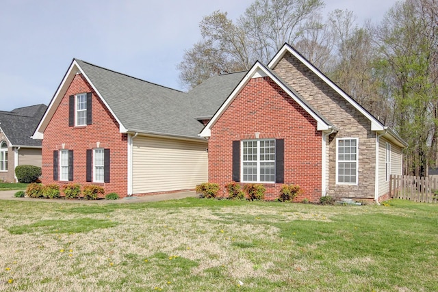 4425 Taylor Hall Ln, Adams, TN 37010 - view of front of home with fence, stone siding, a front lawn, brick siding, and a shingled roof