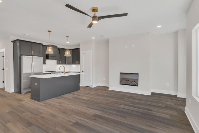 1016 W Kirkland Ave Unit E, Nashville, TN 37216 - kitchen with decorative backsplash, light countertops, stainless steel fridge, ceiling fan, and custom range hood