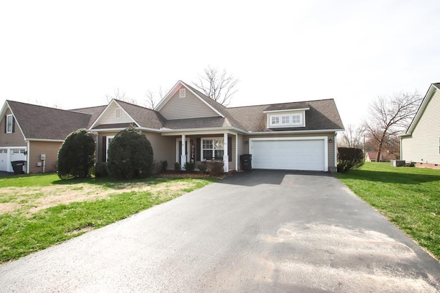 view of front facade featuring aphalt driveway, a garage, and a front lawn