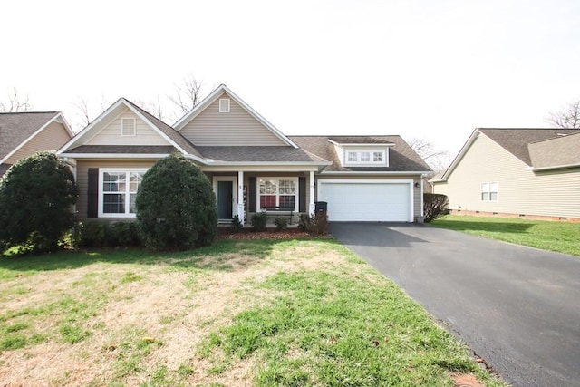 view of front of property with driveway, a front yard, a garage, and roof with shingles