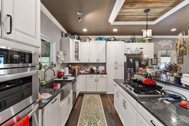 kitchen with white cabinetry, crown molding, dark wood finished floors, a sink, and appliances with stainless steel finishes