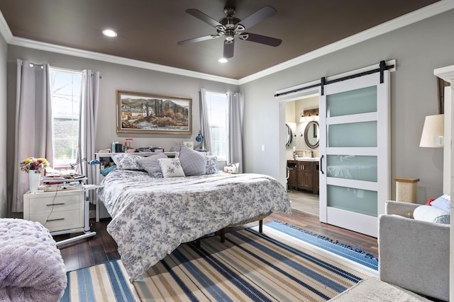 bedroom featuring a barn door, wood finished floors, recessed lighting, and crown molding