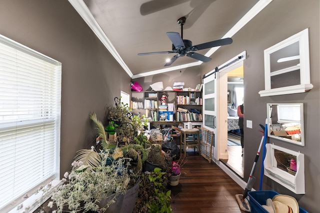 interior space with a barn door, crown molding, wood finished floors, and ceiling fan