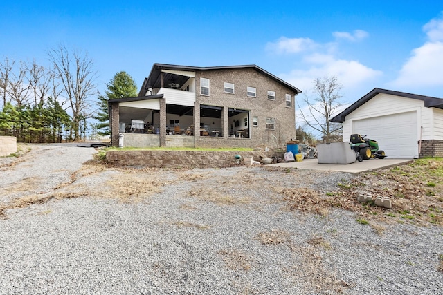 exterior space with brick siding, an outbuilding, and driveway